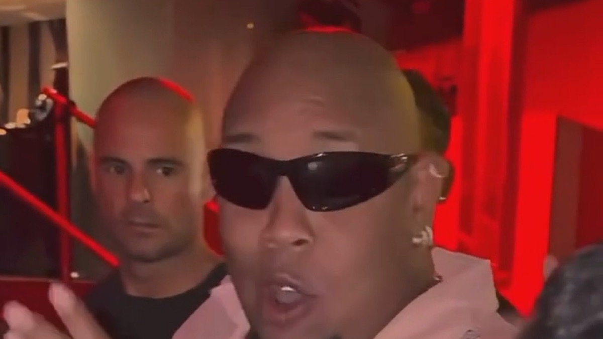Bulin 47 AI video: a man in black sunglasses and a pink mesh shirt freestyles under red club lights