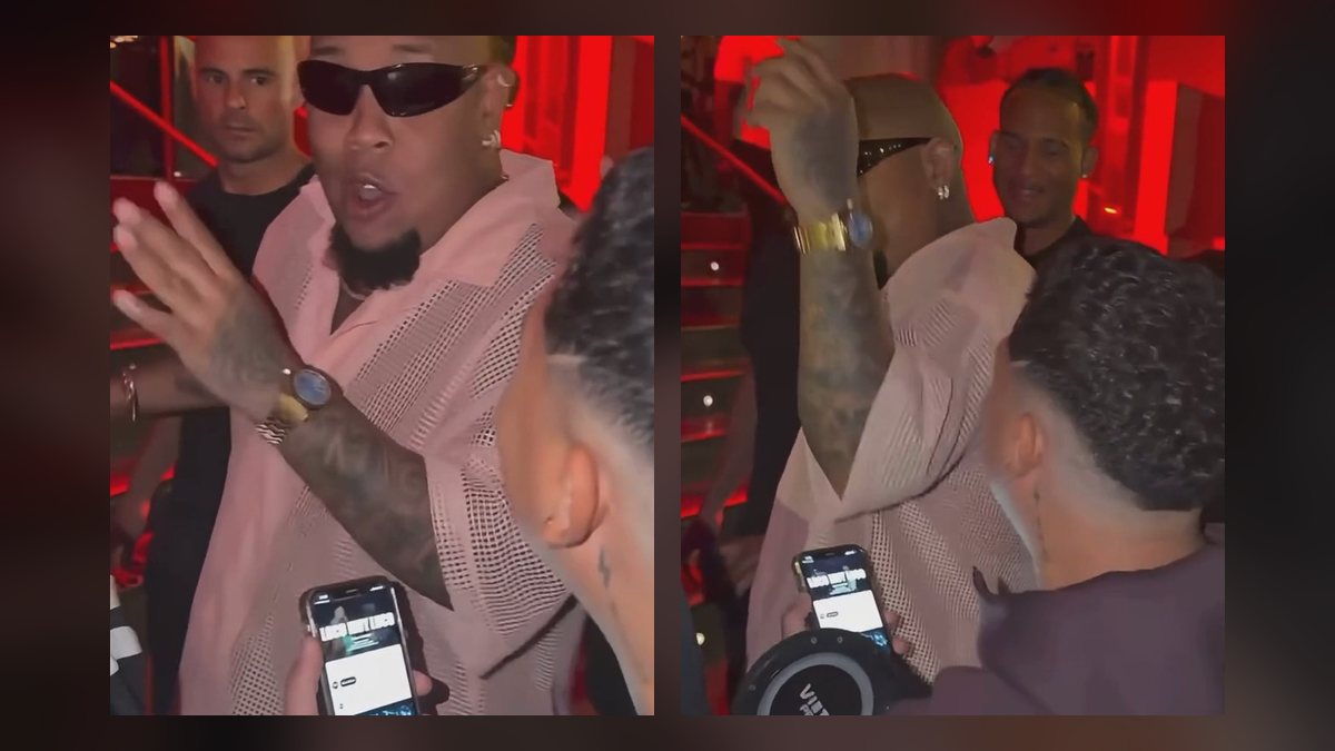 Bulin 47 rapping the freestyle with his hands up under red club lights